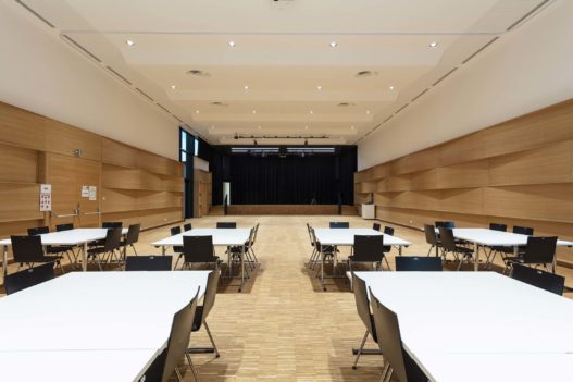 Weiße Holztische und Bestuhlung im Veranstaltungszentrum Gampern